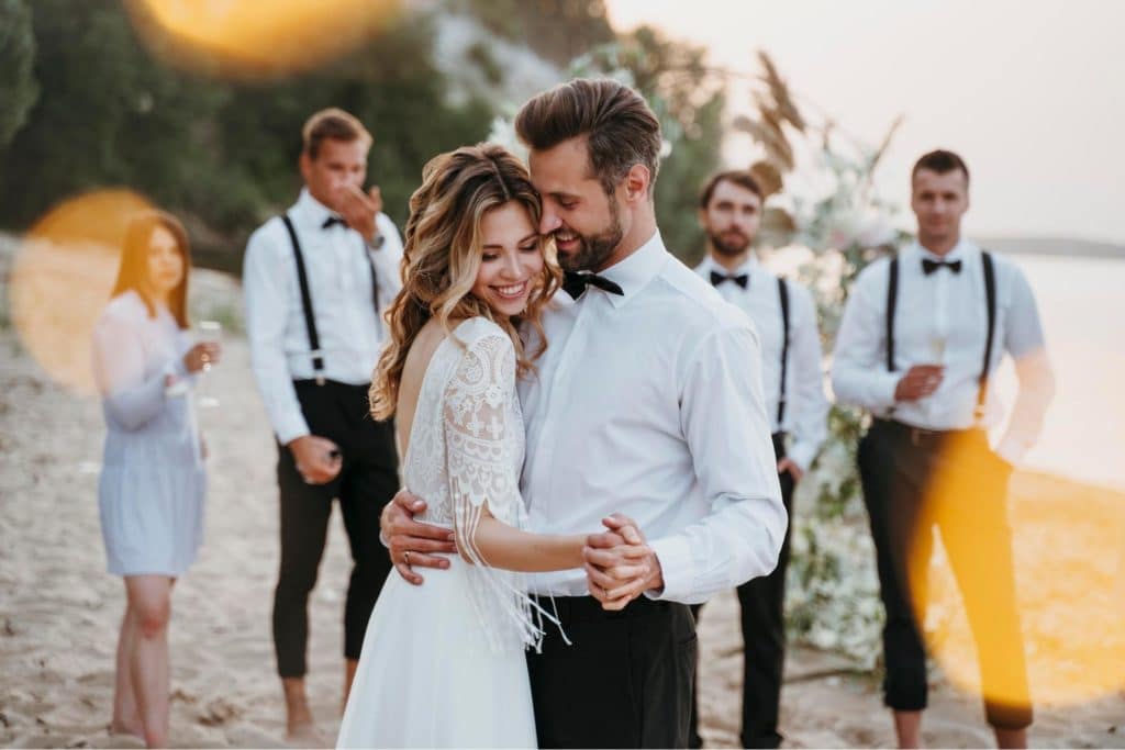 Noivos abraçados em casamento na praia
